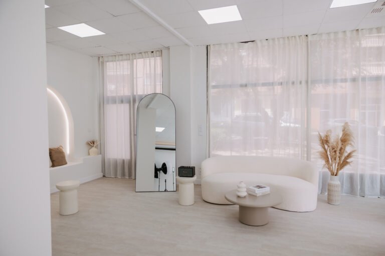 Sala principal con ventanales, espejo de arco y sofá curvo