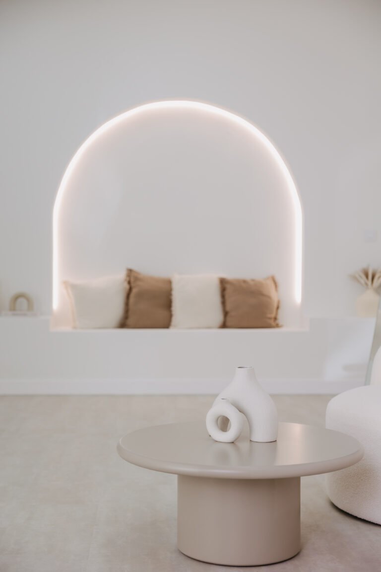 Arco retroiluminado con cojines y mesa auxiliar con decoración