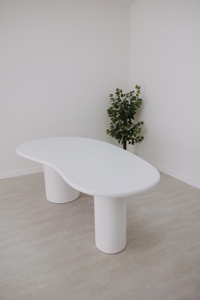 Mesa orgánica blanca con una planta natural