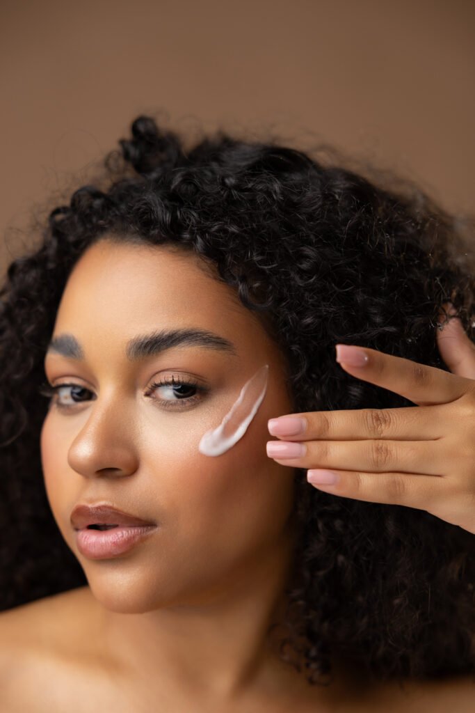 Modelo aplicándose crema en el rostro