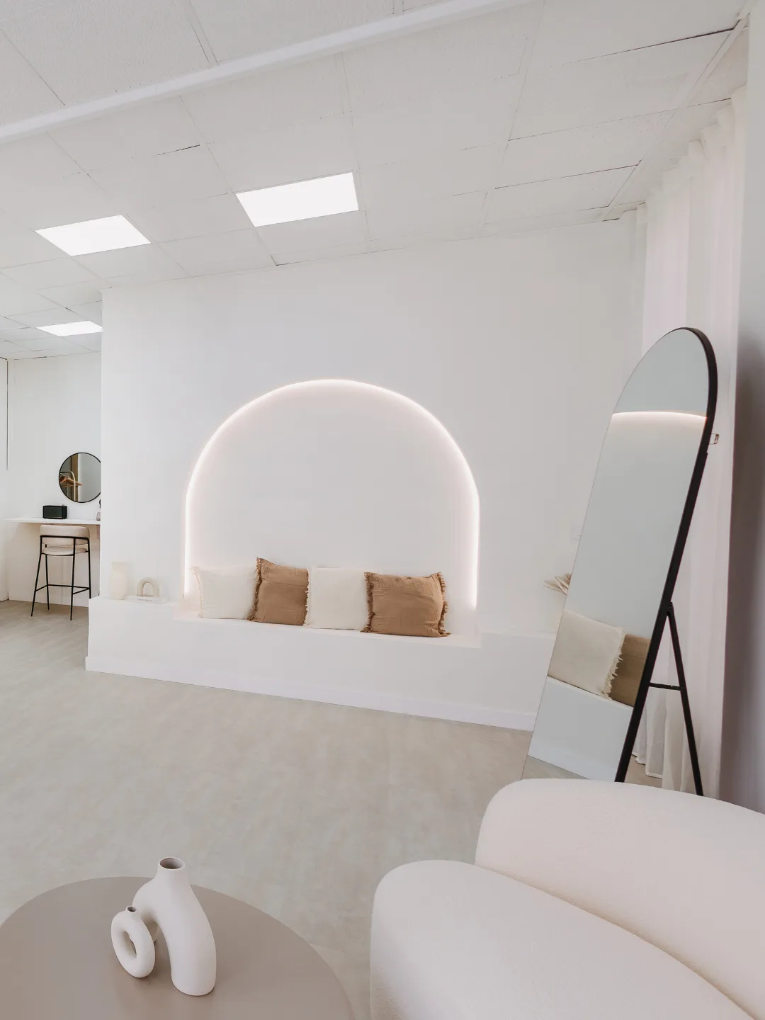 Zona lifestyle del estudio: arco iluminado, cojines y espejo de cuerpo entero